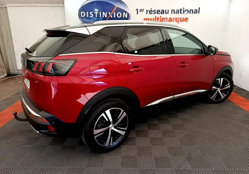 Vue 3/4 arrière droite d’un Peugeot 3008 GT rouge avec toit noir et jantes alliage bicolores.