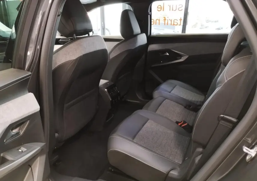 Vue côté droit de l'habitacle arrière du Peugeot 5008 gris titanium avec sellerie tissu et cuir gris foncé.