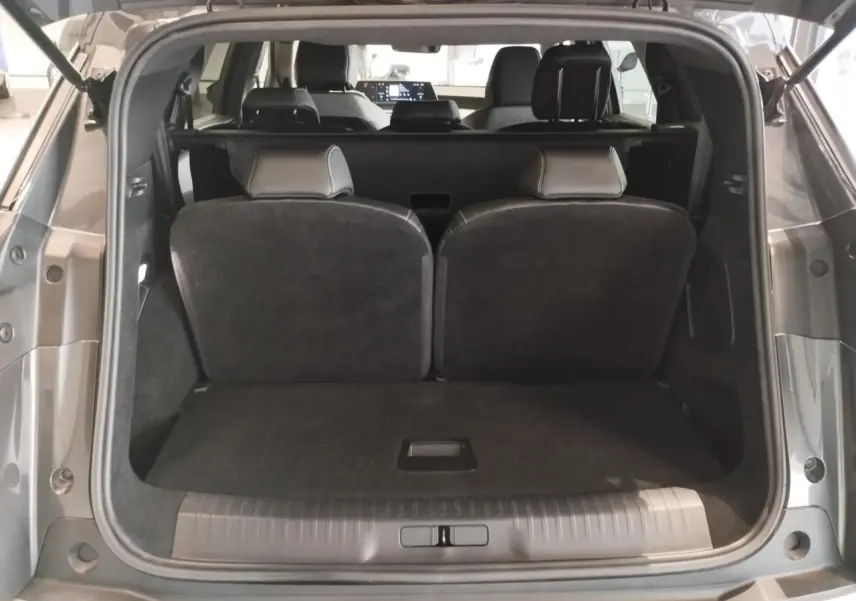 Coffre ouvert du Peugeot 5008 gris titanium, vue arrière montrant les sièges rabattus et l'intérieur spacieux.