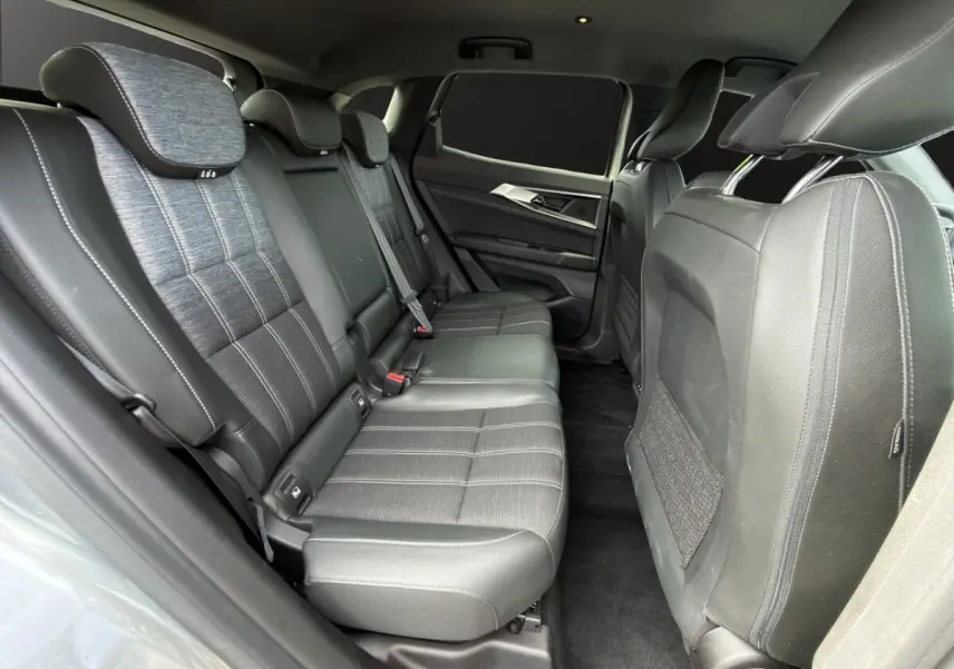 Vue latérale intérieure des sièges arrière en cuir noir du Renault Austral gris foncé, avec banquette 3 places et appuie-têtes.