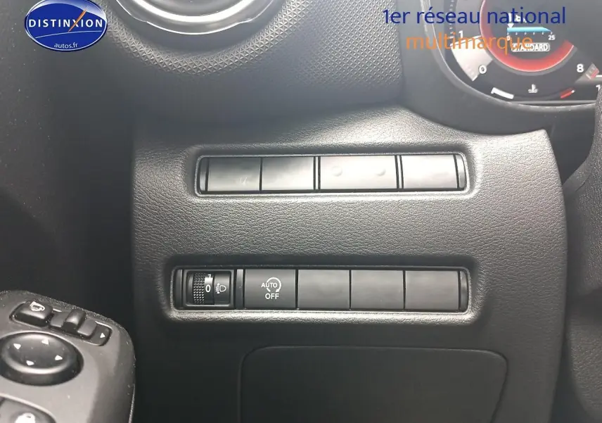 Détail du tableau de bord noir du Nissan Juke 2025 avec commandes d'éclairage et réglages côté gauche.