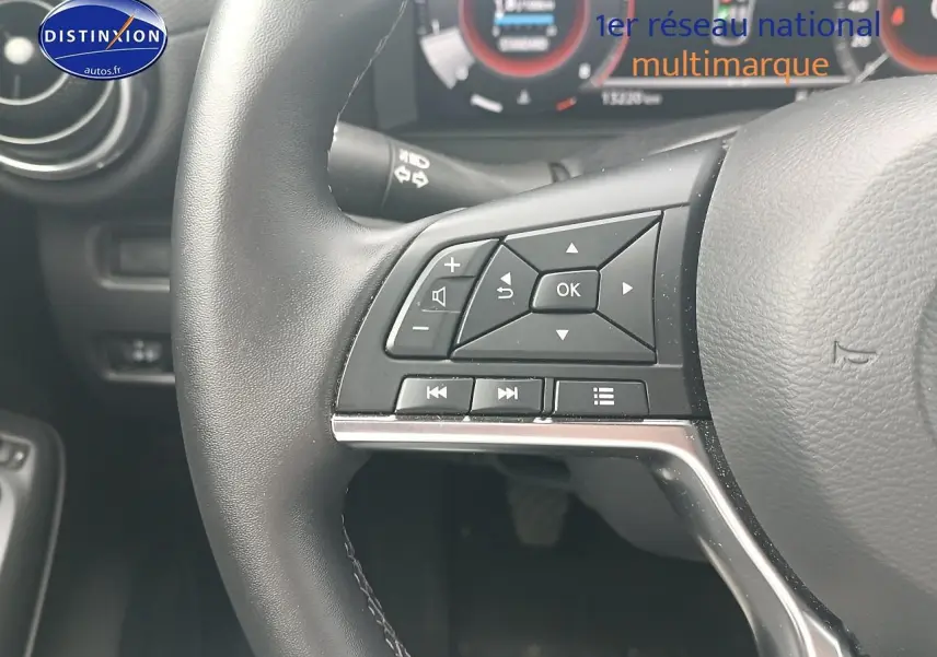Gros plan sur le volant cuir multifonction côté gauche du Nissan Juke gris 2025 avec commandes audio intégrées.