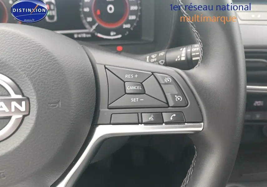 Gros plan sur le volant cuir multifonction du Nissan Juke gris 2025, avec commandes de régulateur et téléphone intégrées.