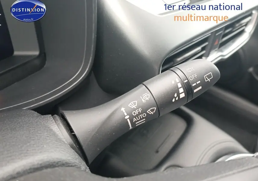 Gros plan sur la commande des essuie-glaces dans l'habitacle du Nissan Juke gris 2025, côté gauche du volant.