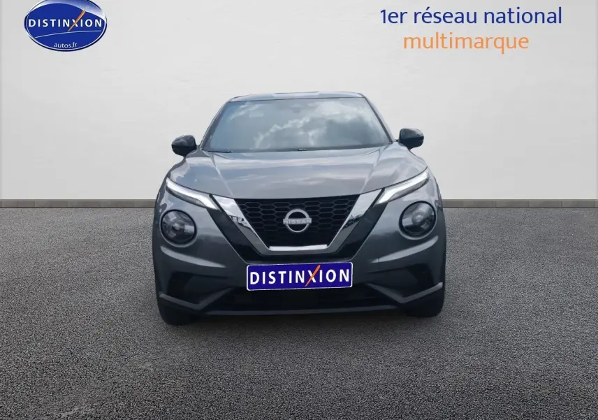 Vue frontale d'un Nissan Juke gris 2025 avec calandre en V caractéristique et phares ronds distinctifs.