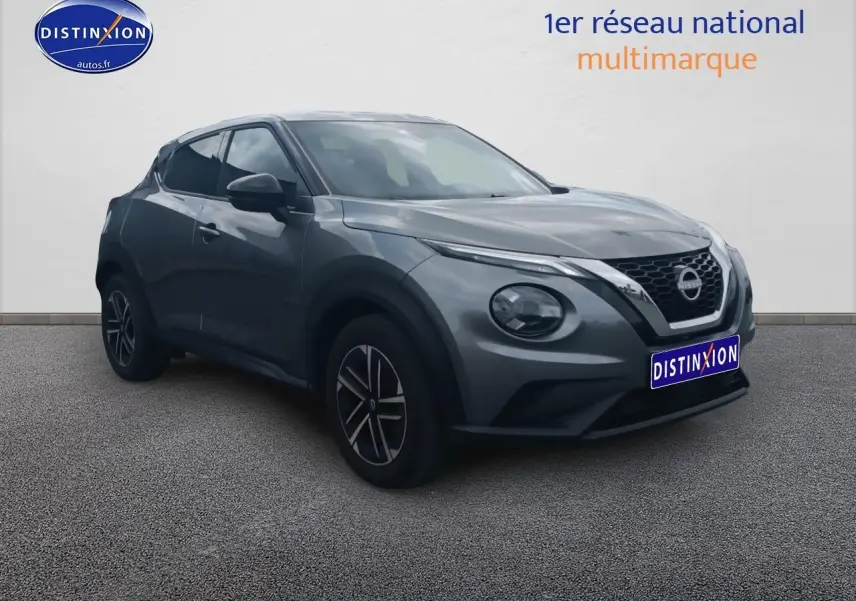 Nissan Juke gris 2025 en 3/4 avant droit, avec phares ronds et jantes alliage noires.