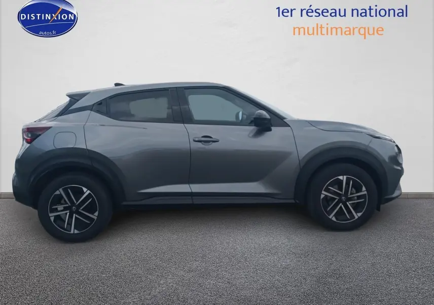 Profil côté gauche du Nissan Juke gris 2025 avec jantes alu et poignées ton carrosserie sur fond neutre.