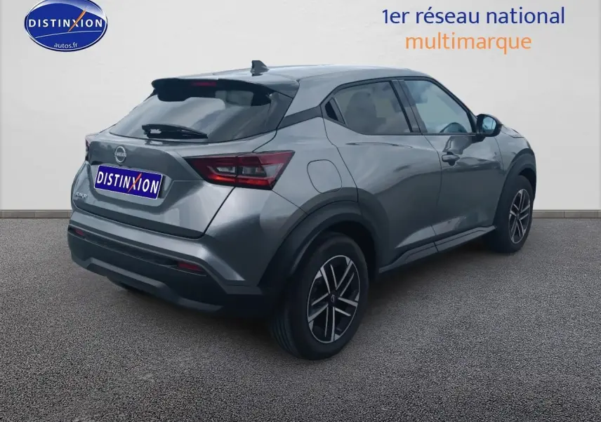 Nissan Juke gris en 3/4 arrière droit, avec jantes alliage et vitres arrière surteintées.