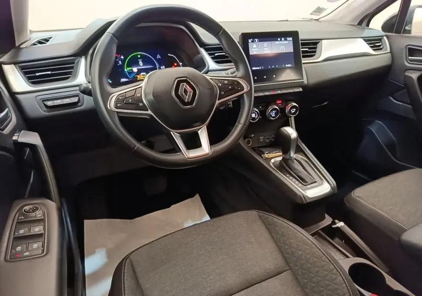 Vue intérieure avant du Renault Captur Business E-Tech 2022, volant cuir multifonctions et écran tactile central.