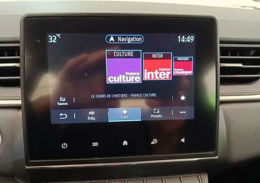 Écran tactile central du tableau de bord du Renault Captur Business E-Tech gris clair, affichant la radio et la navigation.
