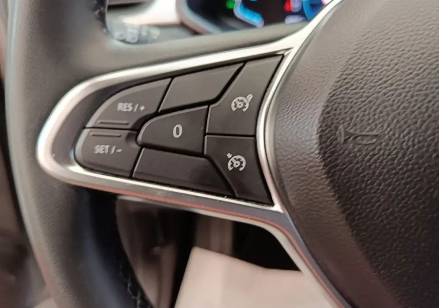 Gros plan sur le côté gauche du volant cuir synthétique du Renault Captur Business E-Tech hybride gris clair 2022, avec commandes multifonctions.