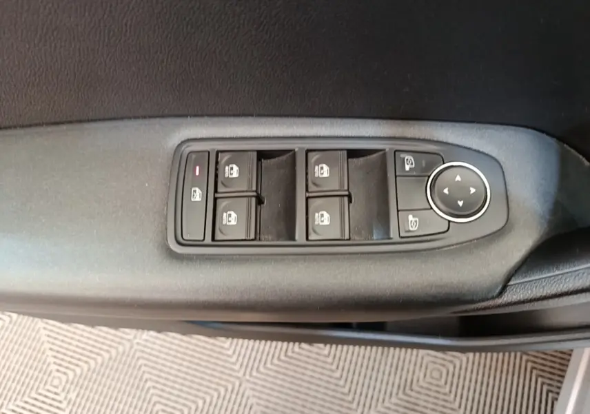 Gros plan sur les commandes de lève-vitres et rétroviseurs sur la porte côté conducteur d’un Renault Captur Business E-Tech hybride.
