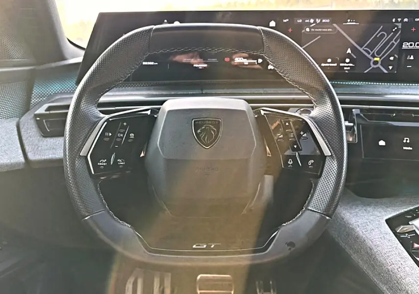 Vue frontale du volant cuir noir multifonction de la Peugeot 3008 gris 1.2 hybrid 145 GT avec tableau de bord numérique.