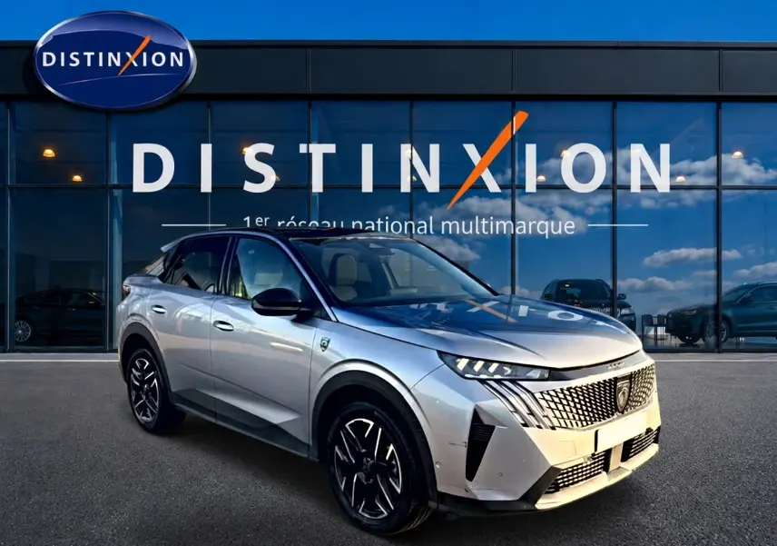 Peugeot 3008 gris 3/4 avant droit avec calandre distinctive et jantes alu noires devant showroom Distinxion.