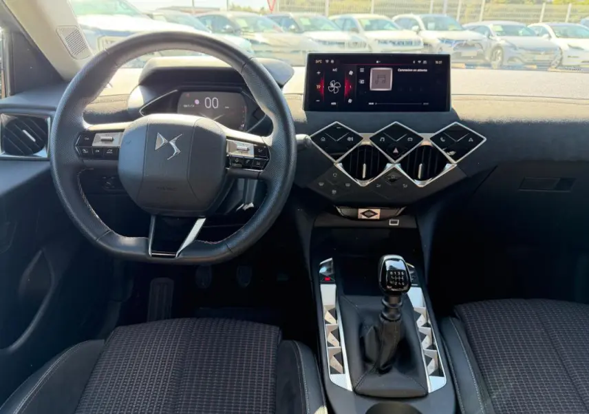 Intérieur du DS3 2024 en vue frontale, volant compact, tableau de bord moderne avec écran tactile et levier de vitesse manuel.