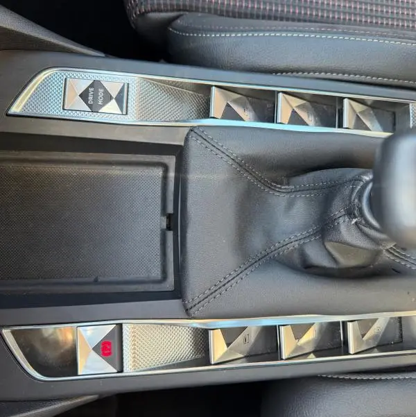 Gros plan sur la console centrale grise du DS3 2024, avec levier de vitesse manuel et boutons en relief chromés.
