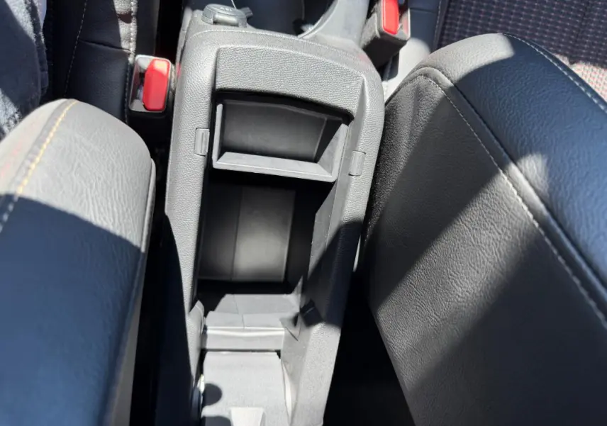 Vue rapprochée de la console centrale ouverte du DS3 100 BVM6 Performance Line 2024, intérieur gris avec surpiqûres.