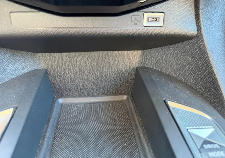 Gros plan sur la console centrale noire du DS3 100 BVM6 Performance Line 2024 avec port USB et bouton Drive Mode.