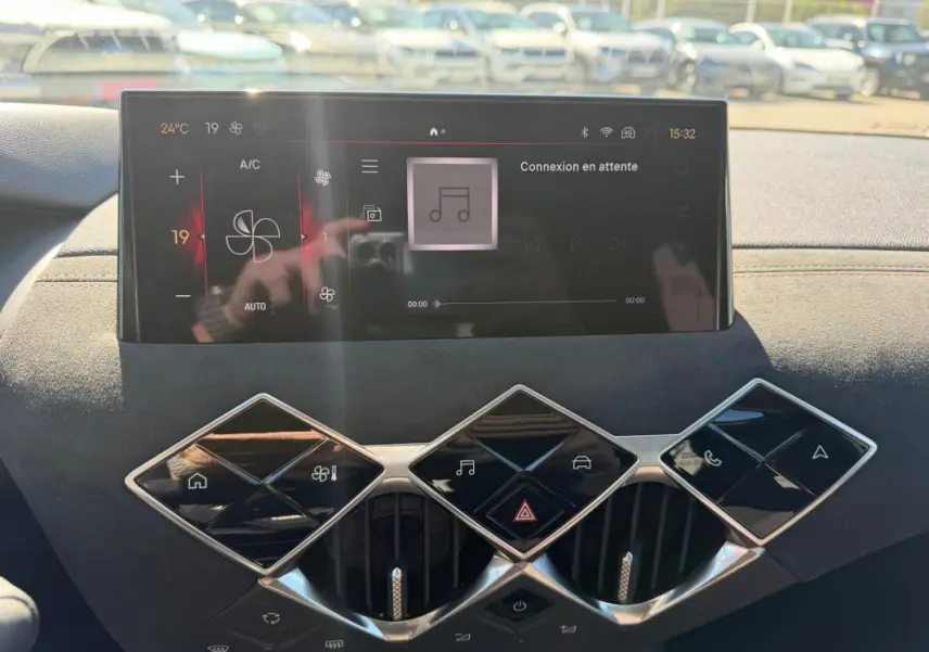 Vue rapprochée de la console centrale du DS3 2024 gris, avec écran tactile et commandes en losange distinctives.