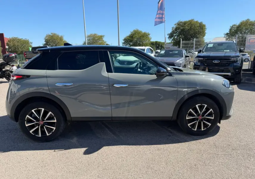 Vue de profil côté gauche d'une DS3 100 BVM6 Performance Line gris 2024 avec toit noir et jantes stylisées.