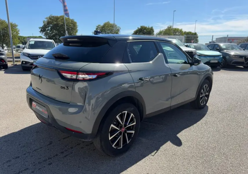 Vue 3/4 arrière droite d'une DS3 100 BVM6 Performance Line gris métallisé avec toit noir et jantes alliage bicolores.
