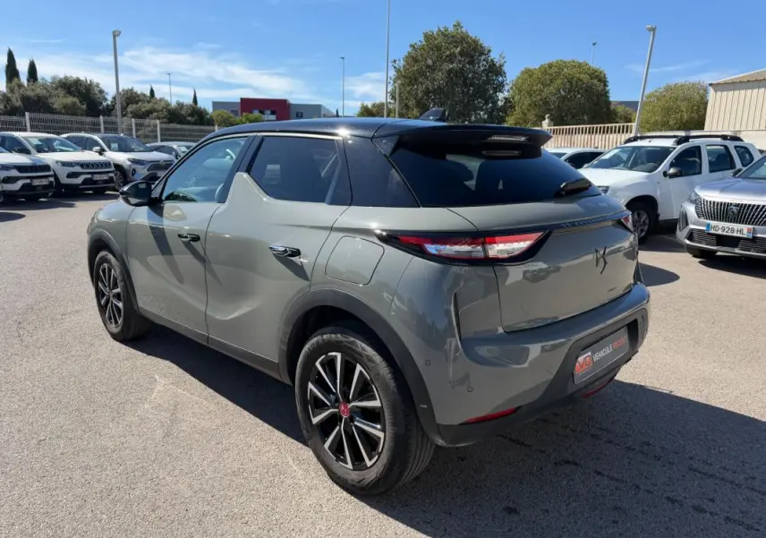 Vue 3/4 arrière droite d'une DS3 100 BVM6 Performance Line gris avec toit noir, garée en extérieur par temps ensoleillé.