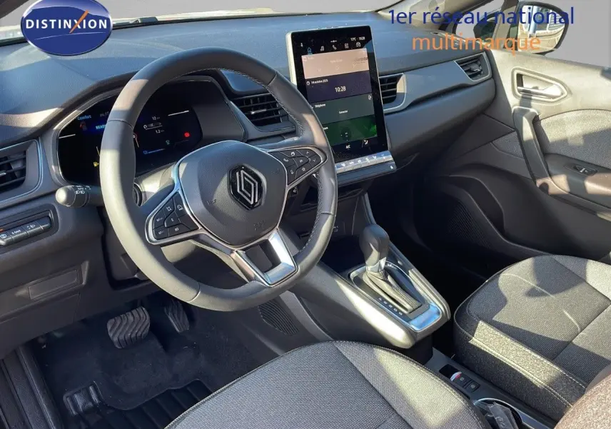 Vue intérieure avant du Renault Captur E-Tech gris rafale avec tableau de bord numérique et écran tactile central vertical.