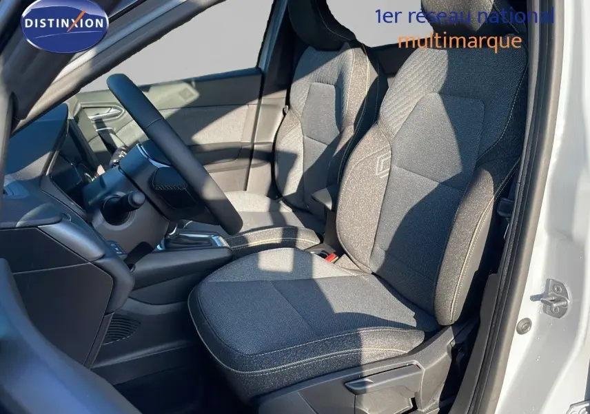Vue intérieure côté conducteur du Renault Captur E-Tech Hybrid 2025 avec sièges tissu gris et volant noir.
