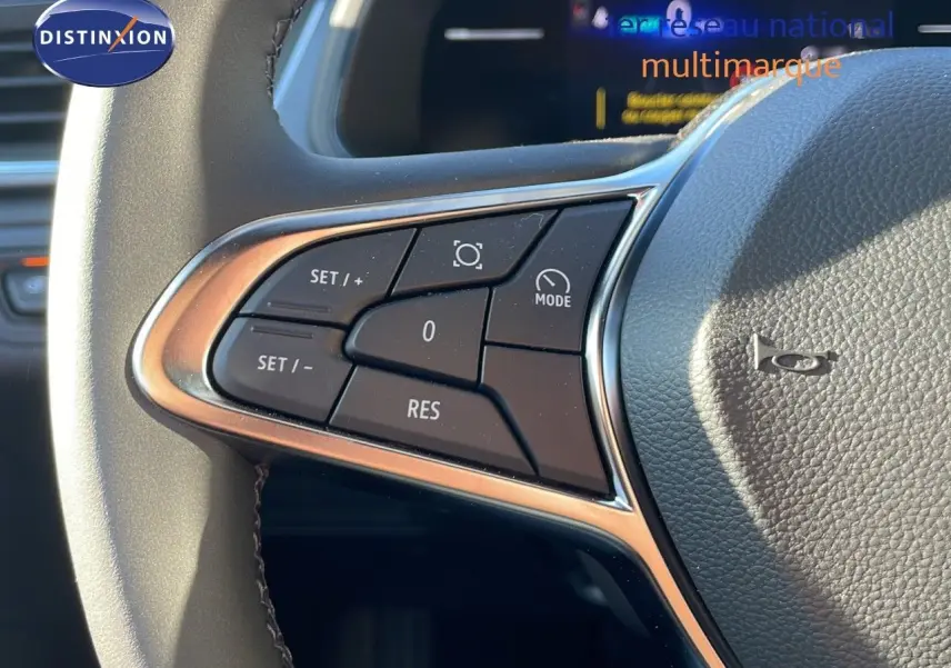 Gros plan sur les commandes au volant du Renault Captur E-Tech hybride 2025, finition gris rafale avec détails chromés.