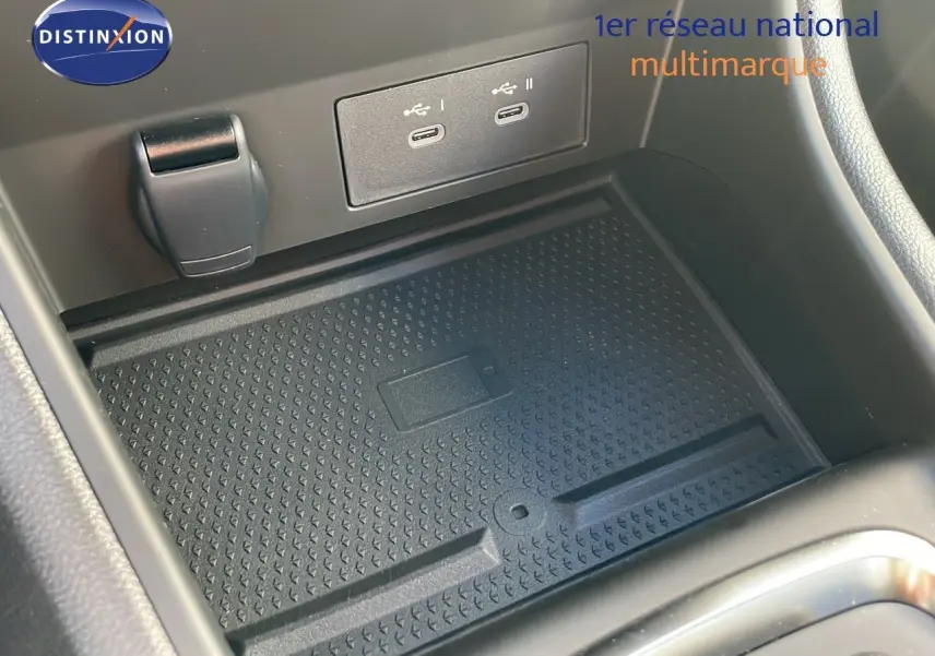 Vue rapprochée de la console centrale du Renault Captur gris Rafale avec prises USB et tapis antidérapant noir.