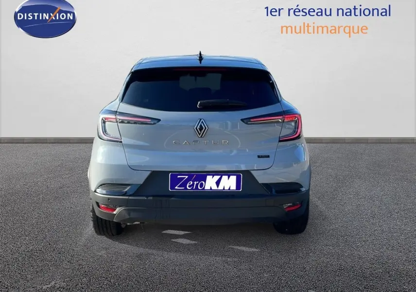 Vue arrière d'un Renault Captur E-Tech hybride gris Rafale avec toit noir et feux LED allumés.