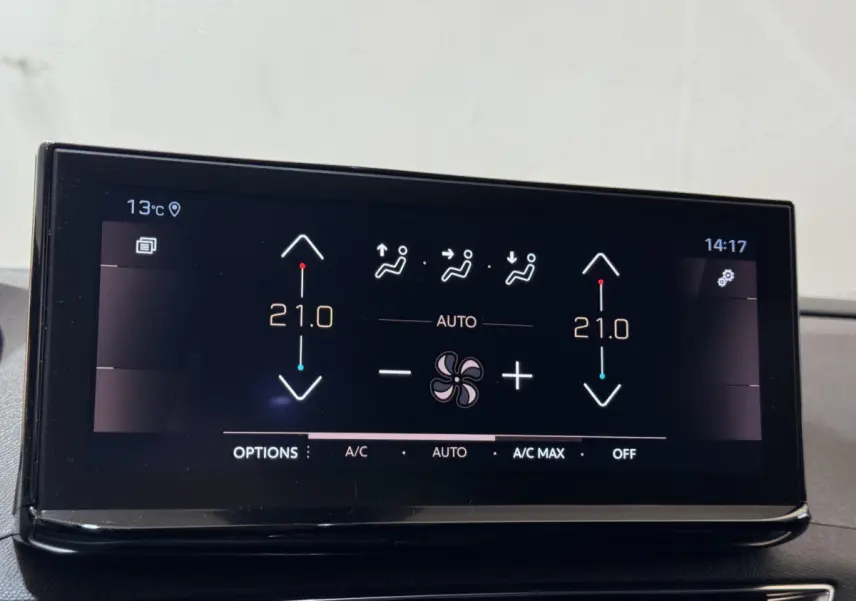 Écran tactile central affichant la climatisation 2 zones à 21°C dans un Peugeot 3008 gris clair, vue intérieure frontale.