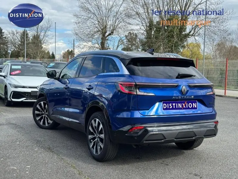 Vue 3/4 arrière droite d'un Renault Austral 2025 bleu Outremer avec toit noir étoilé et feux arrière LED distinctifs.