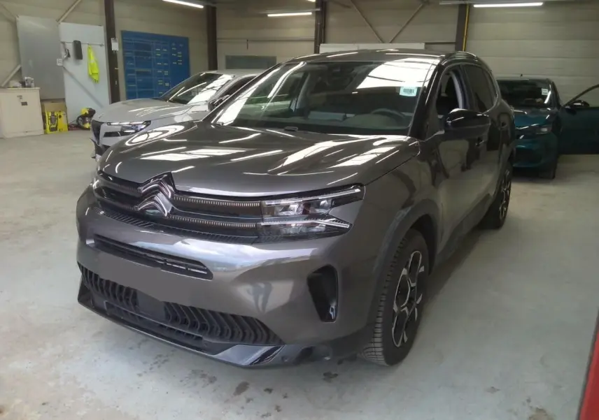 Citroën C5 Aircross gris platinium en 3/4 avant droit, SUV hybride essence avec signature lumineuse distinctive.