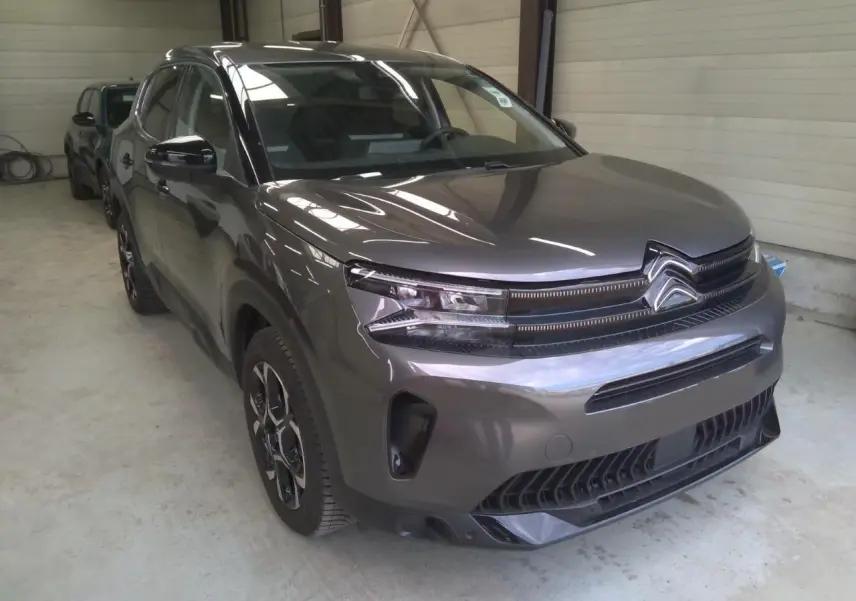 Citroën C5 Aircross 2025 gris platinium en 3/4 avant droit, avec calandre distinctive et phares LED fins.