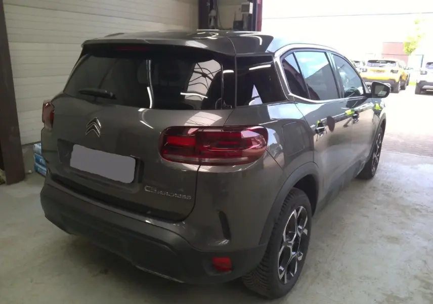 Vue 3/4 arrière droite du Citroën C5 Aircross gris platinium avec toit noir et feux arrière LED distinctifs.