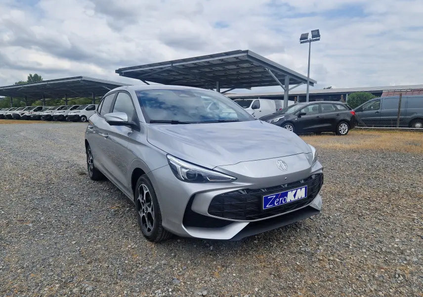 Vue 3/4 avant d'une MG3 1.5L Hybrid+ 195CH Luxury couleur argent Cosmic Silver Metal sur un parking extérieur.