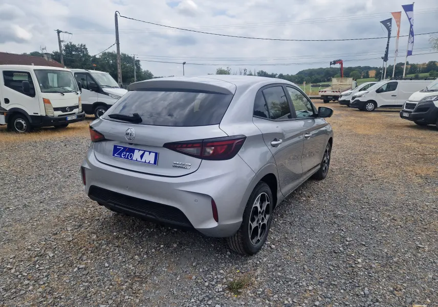 Vue 3/4 arrière droite d'une MG3 1.5L Hybrid+ 195ch Luxury en Cosmic Silver Metal sur un parking gravillonné.