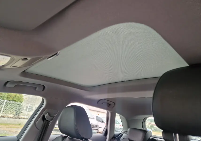 Toit ouvrant panoramique fermé vu de l'intérieur arrière de l'Audi A3 Sportback noir 2019, avec sièges en cuir.