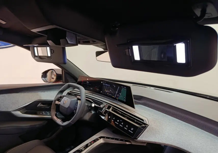 Vue intérieure du tableau de bord et volant cuir noir du Peugeot 3008 1.2 Hybrid 145 E-DCS6 GT avec écran tactile panoramique.