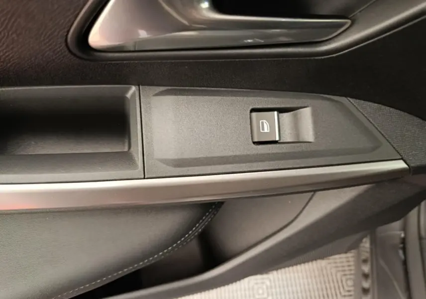 Détail de la commande de lève-vitre côté conducteur du Peugeot 3008 noir, avec garniture intérieure en cuir noir.