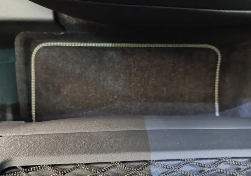 Vue rapprochée du tapis de sol avant noir avec surpiqûres claires dans un Peugeot 3008 1.2 Hybrid 145 GT.