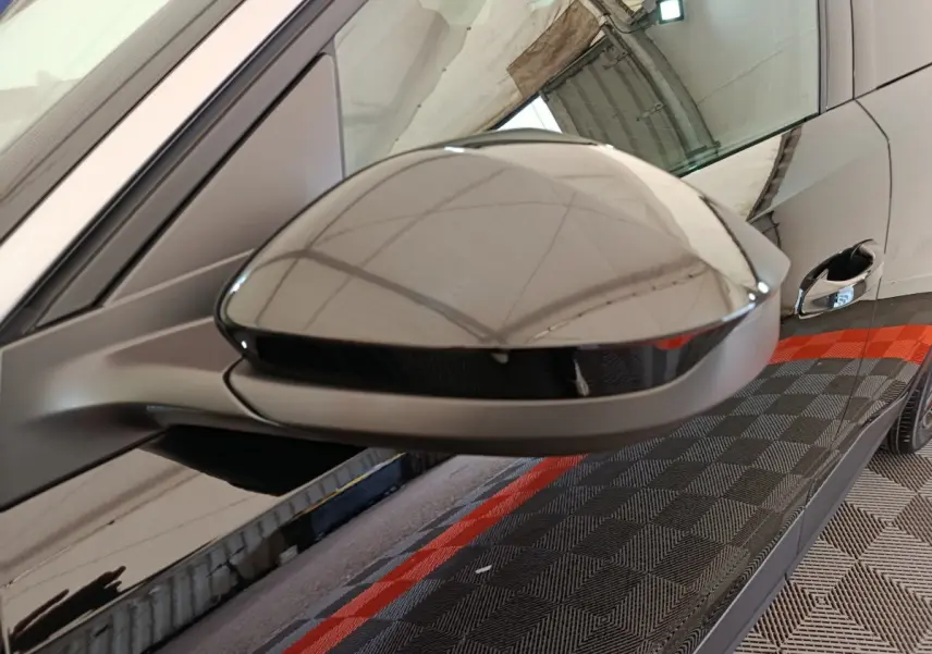 Rétroviseur droit noir brillant de la Peugeot 3008 1.2 Hybrid 145 GT, vue rapprochée avec reflet du plafond.