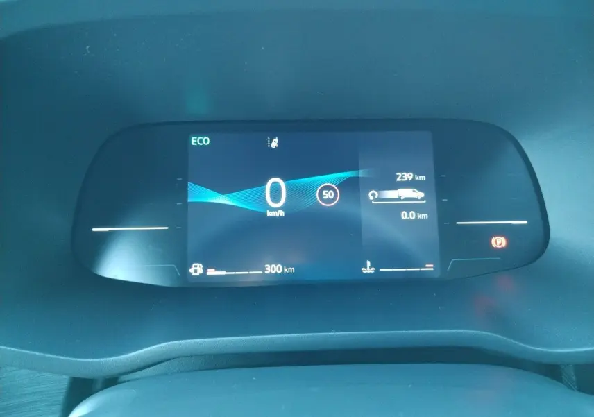 Tableau de bord numérique du Nissan Primastar blanc 2025 affichant vitesse zéro et autonomie restante.