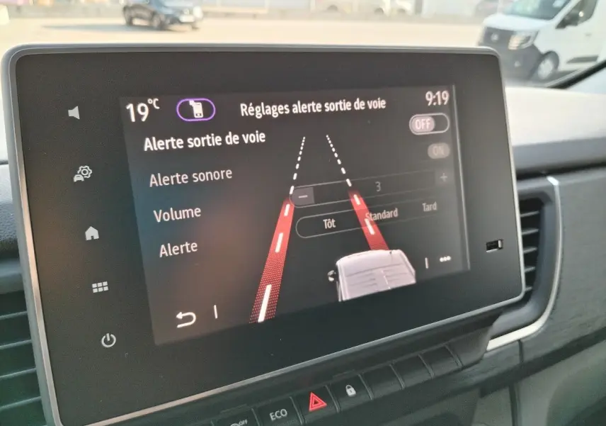 Écran tactile du tableau de bord du Nissan Primastar blanc 2025 montrant les réglages d'alerte de sortie de voie.