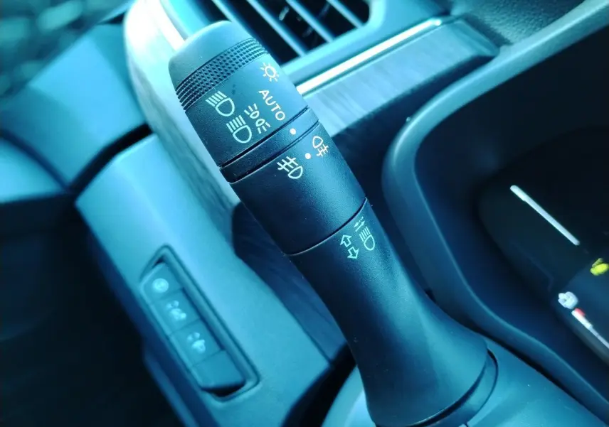 Gros plan sur la commande des phares et clignotants dans l'habitacle du Nissan Primastar blanc 2025.