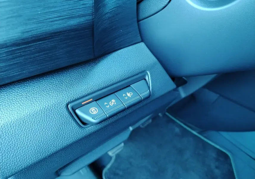 Gros plan sur les commandes de réglage d'éclairage et verrouillage côté gauche du tableau de bord noir du Nissan Primastar blanc 2025.