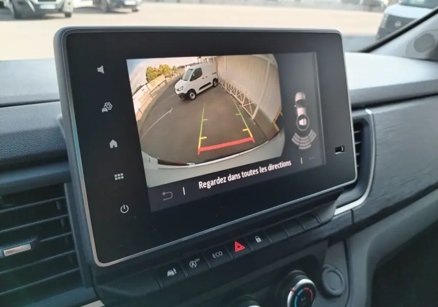 Écran tactile intérieur montrant la caméra de recul du Nissan Primastar blanc, vue depuis le tableau de bord côté droit.