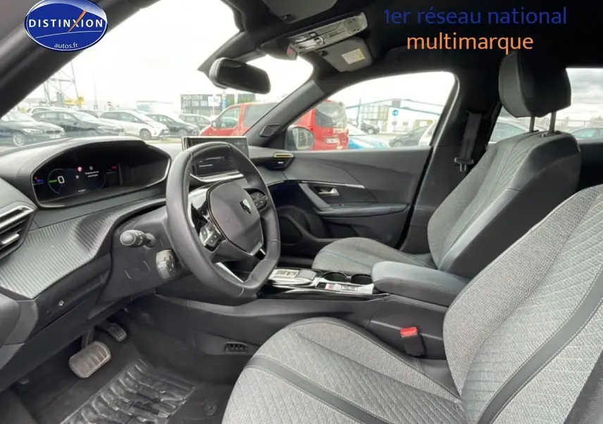 Vue intérieure côté conducteur du Peugeot 2008 E-136 allure 2025, sièges gris et tableau de bord moderne.
