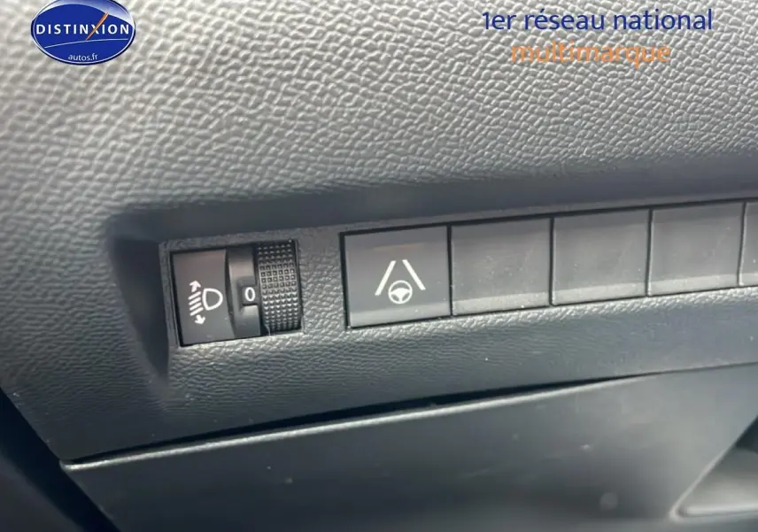 Gros plan sur les commandes d'assistance à la conduite dans un Peugeot 2008 E-136 allure gris sélénite, intérieur noir.